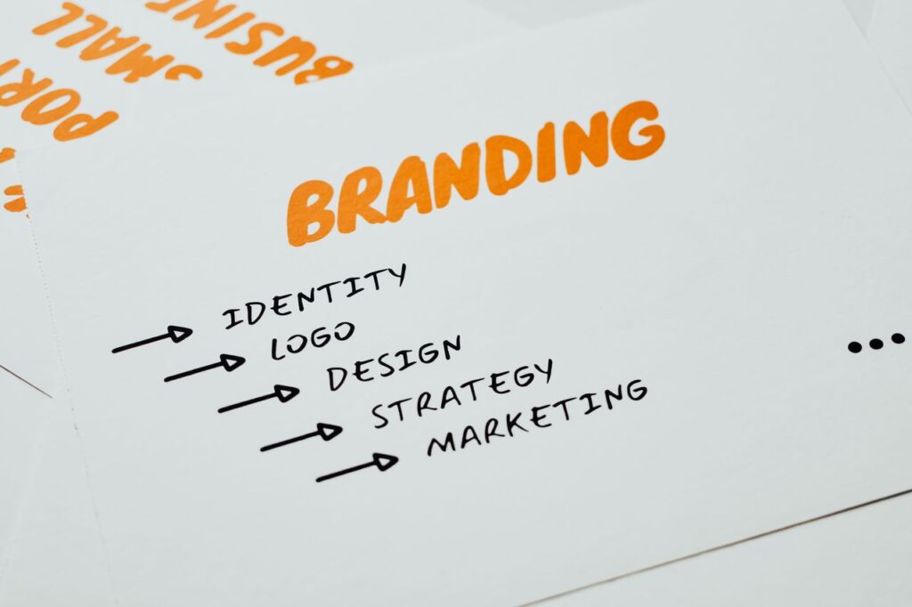 Close-up of a paper with branding, identity, design, strategy, and marketing concepts in orange and black.