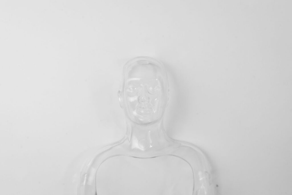 A clear glass figurine on a white backdrop showcasing minimalism and transparency.